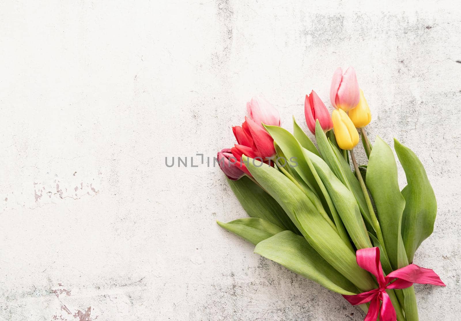 Bunch of spring tulips over white background, top view flat lay