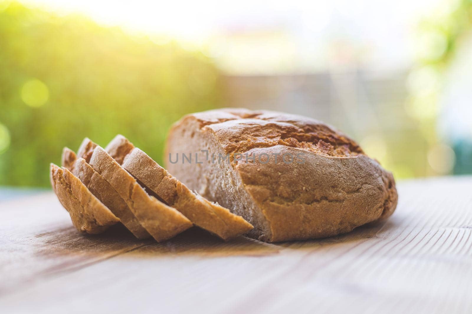 Fresh dark bread in slices, lying on a wooden cutting board. Defocused, blurry background