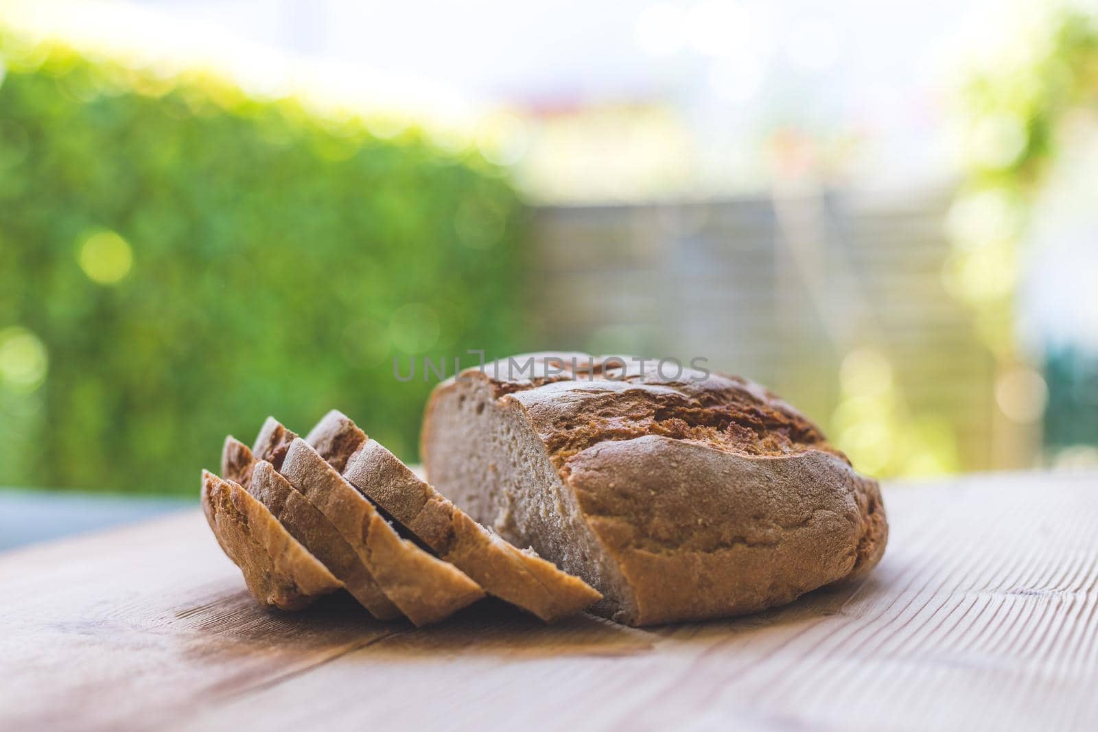 Fresh dark bread in slices, lying on a wooden cutting board. Defocused, blurry background