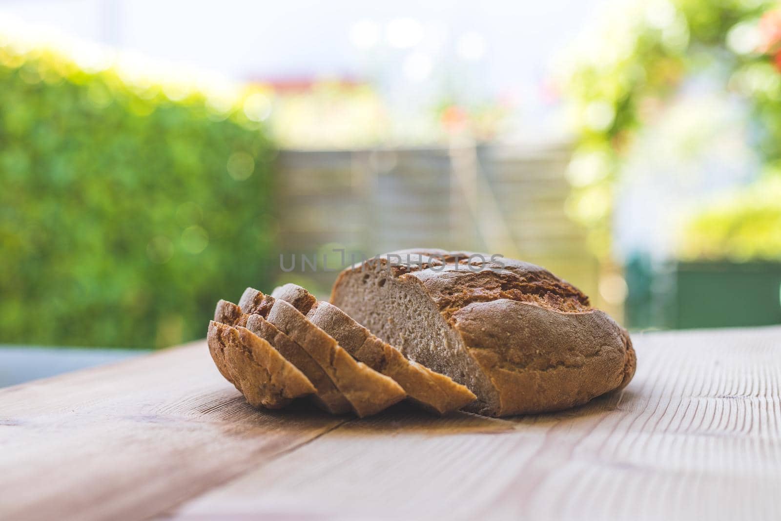Fresh dark bread in slices, lying on a wooden cutting board. Defocused, blurry background