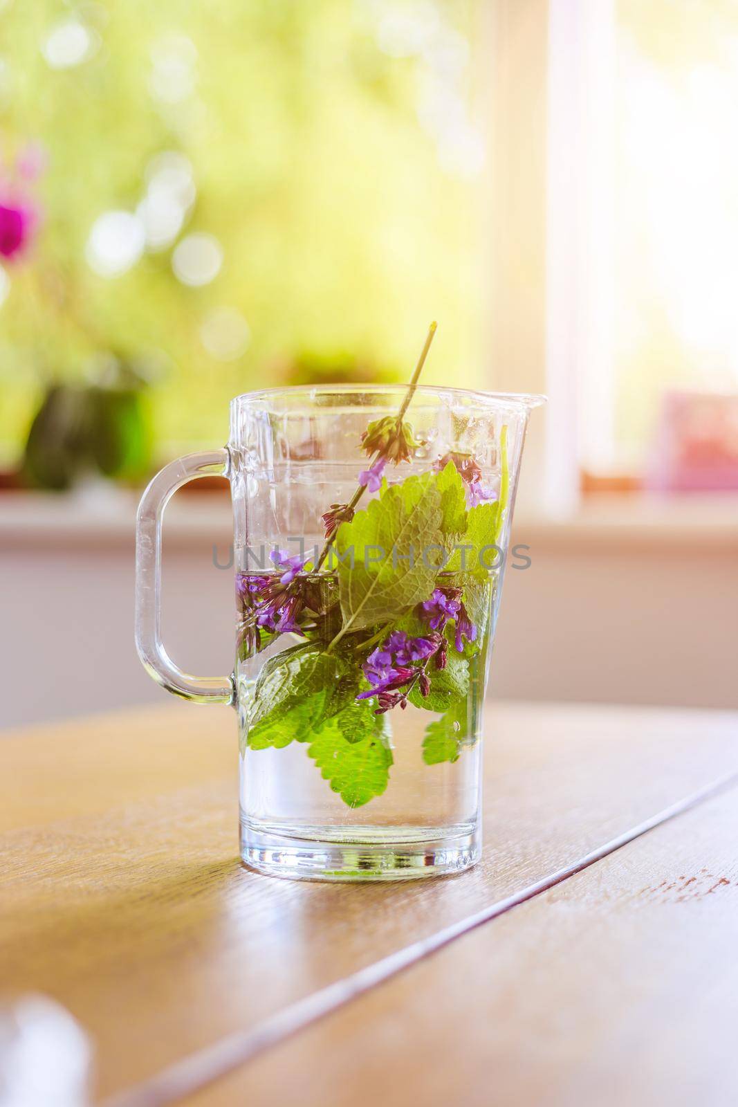 Cold jar of fresh water with delicious colorful herbs