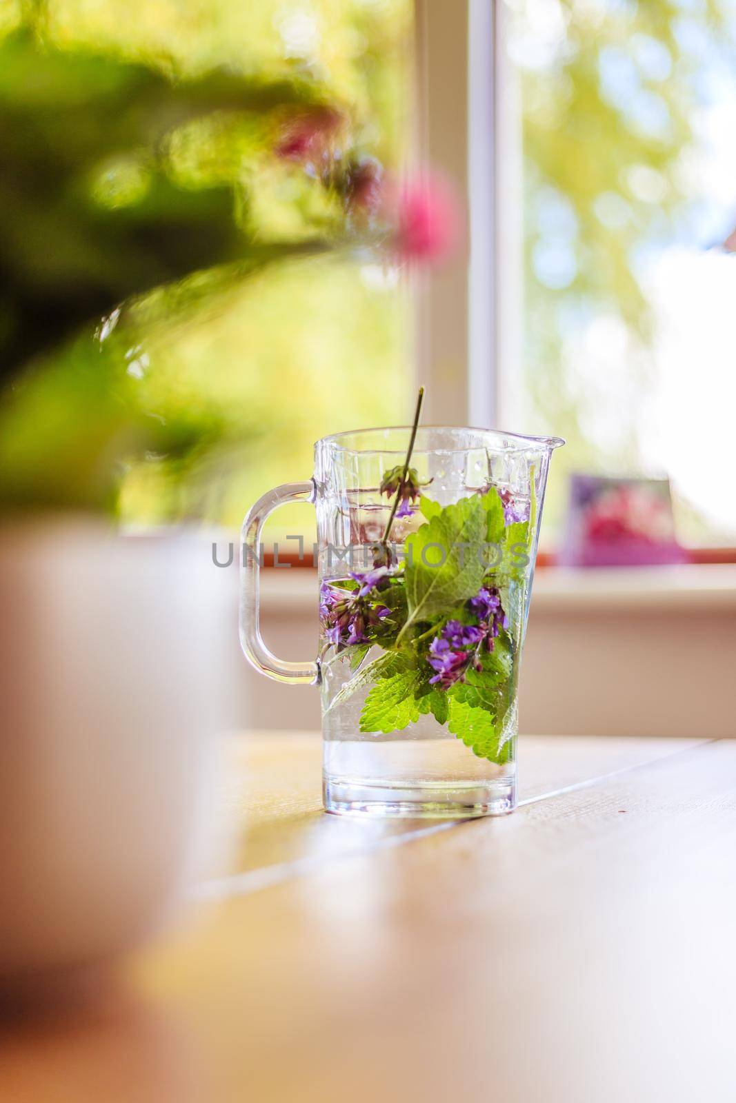 Cold jar of fresh water with delicious colorful herbs