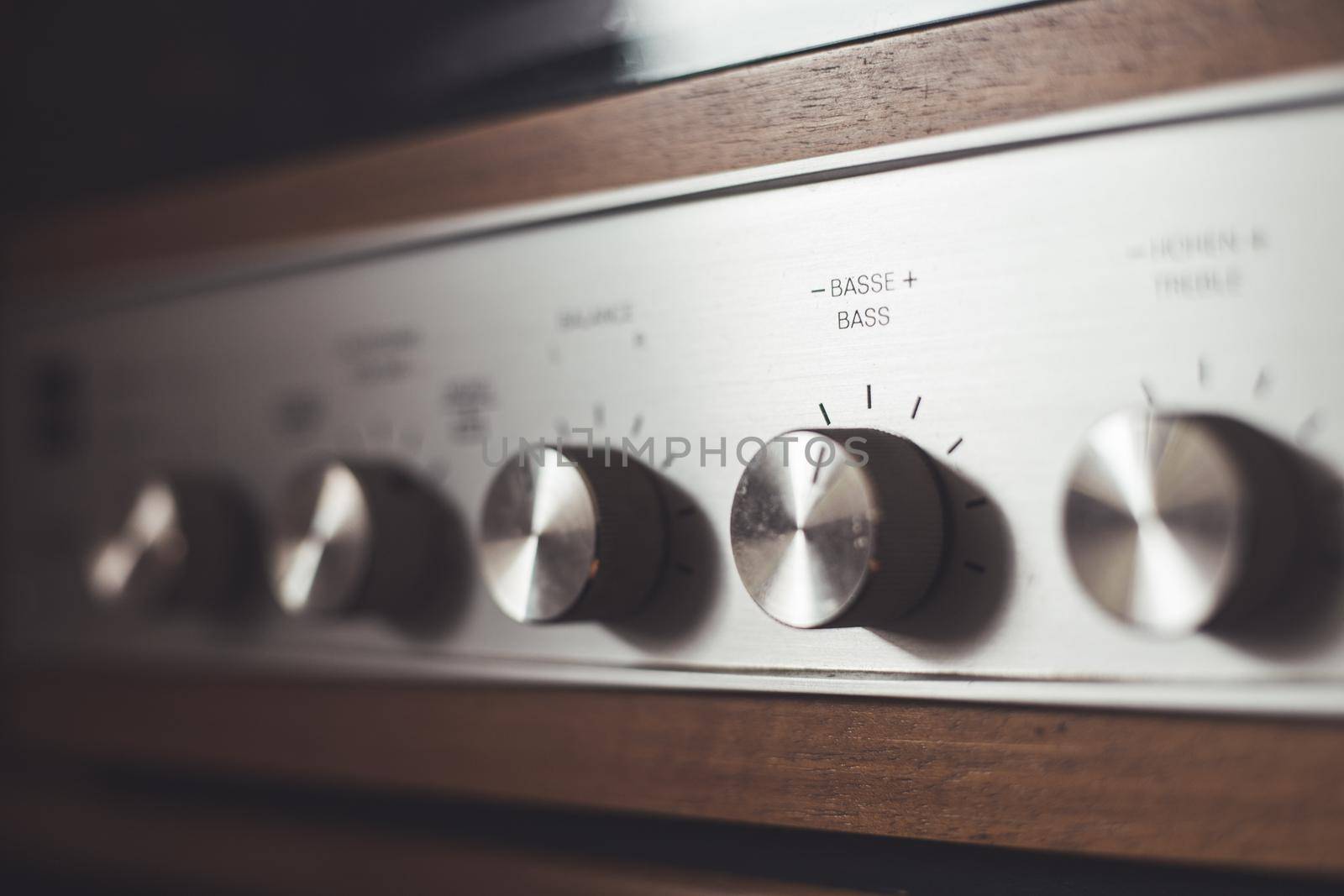 Control knops of silver wooden vintage amplifier, closeup