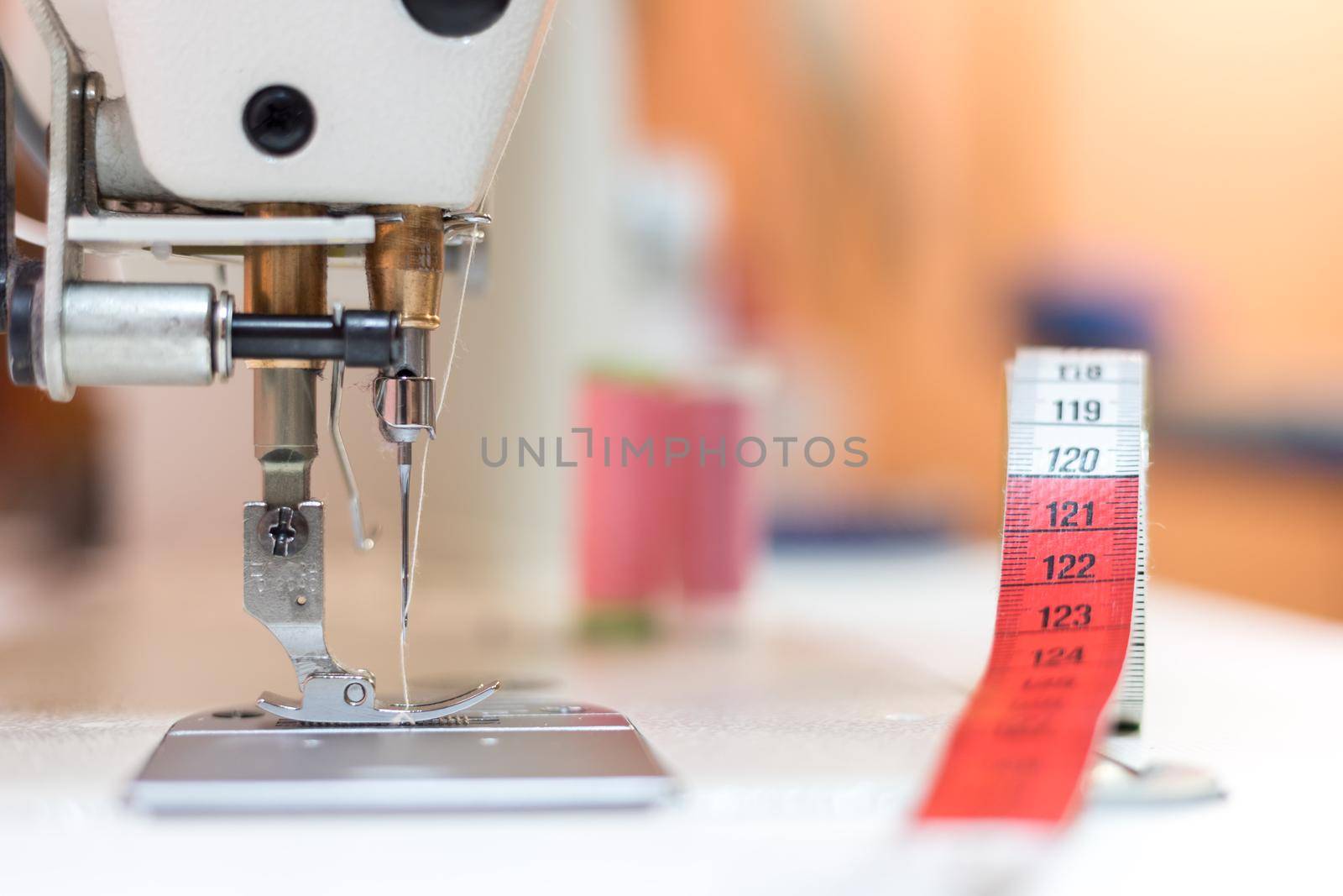 Close up of sewing metal sewing needle with sewing thread, tailor workshop