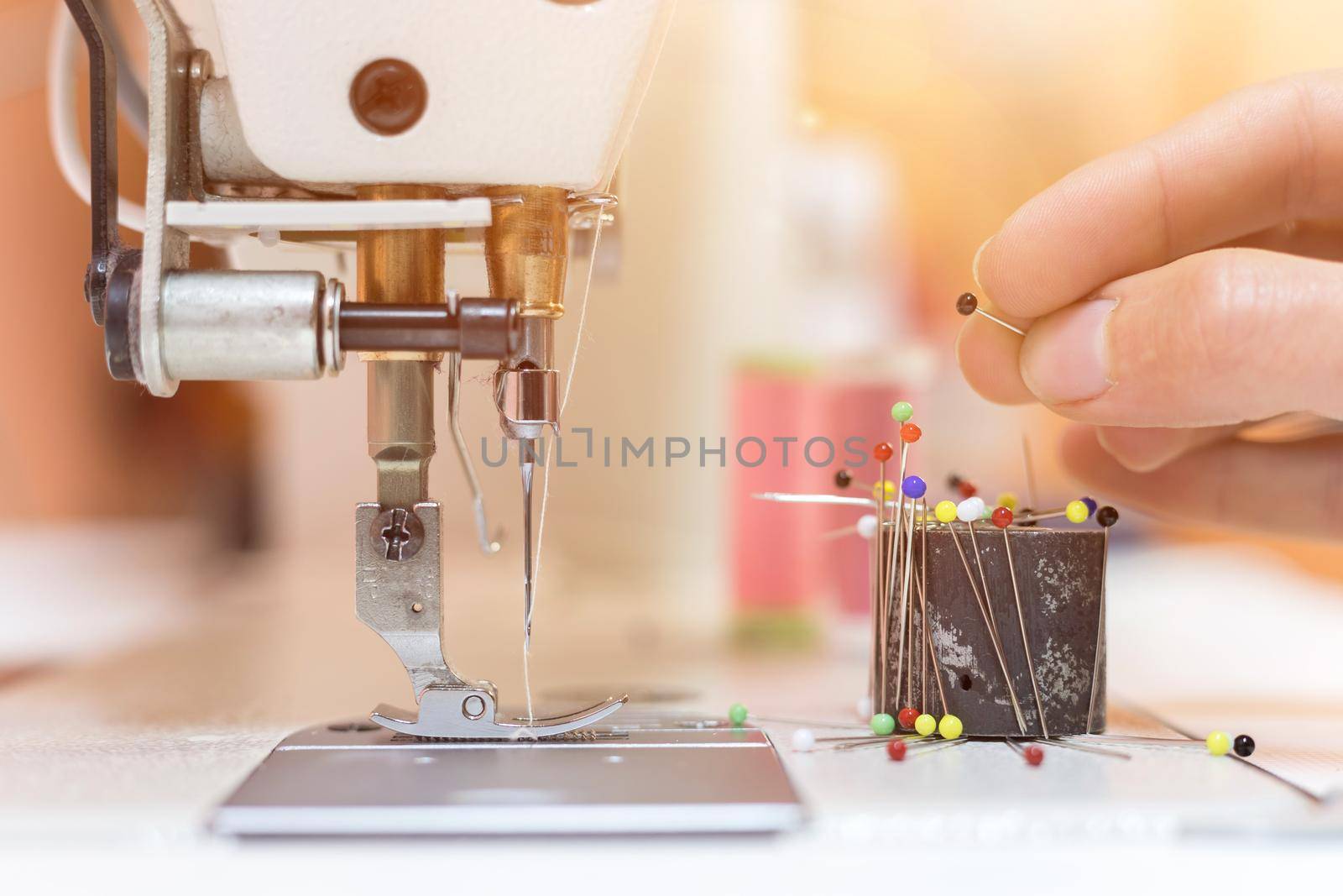 Close up of female hand holding a needle in a tailor workshop