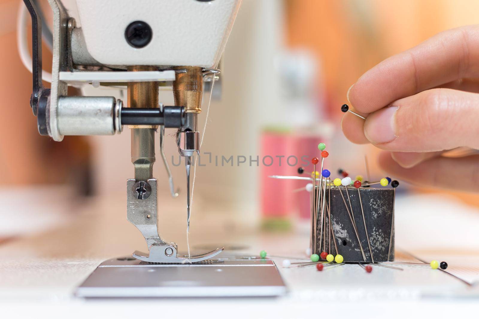 Close up of female hand holding a needle in a tailor workshop