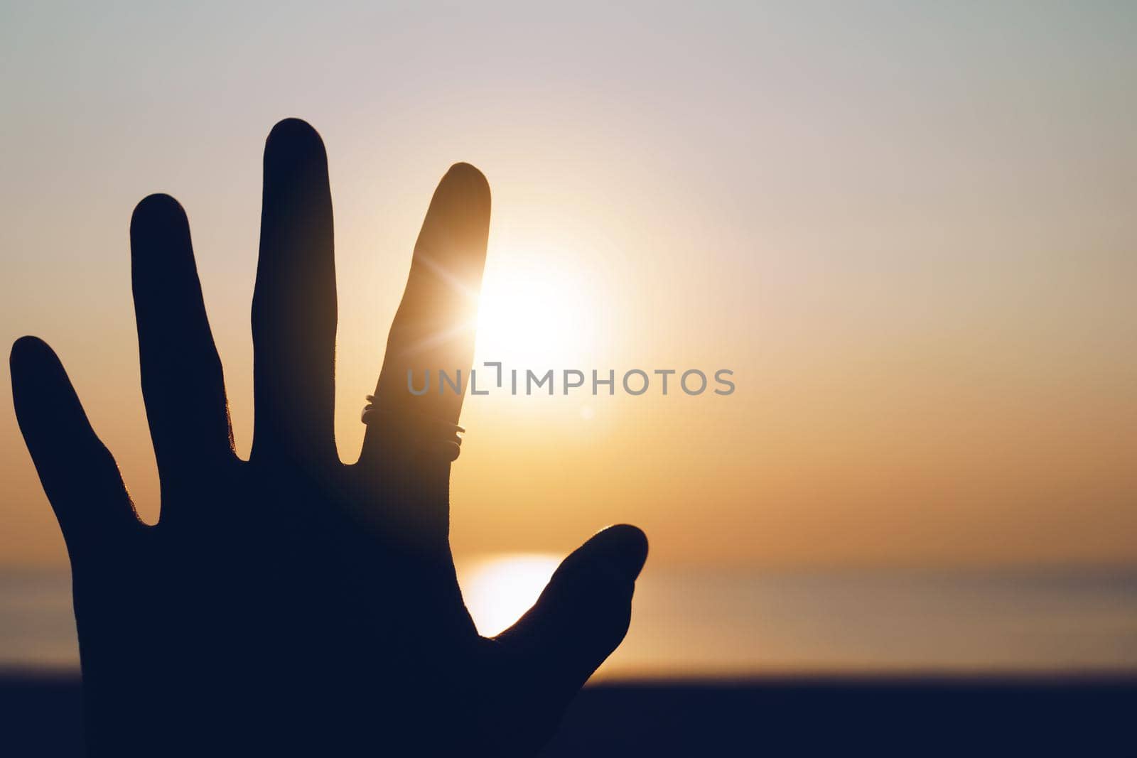 Hand reach out to sunset sky beach sand nature background. Relax and rest in vacation time.