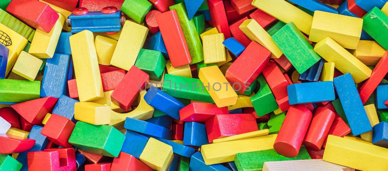 Playing with wooden toy blocks in kindergarten or preschool by Daxenbichler