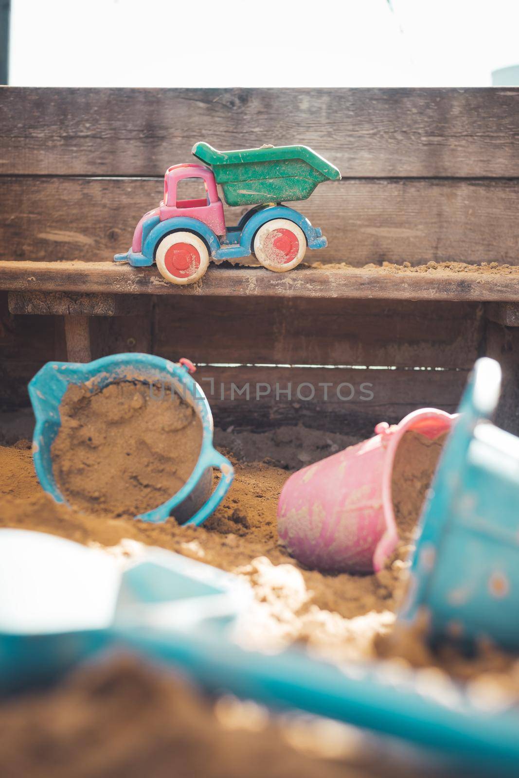 Children plastic toys in the sand box. Truck, selective focus.