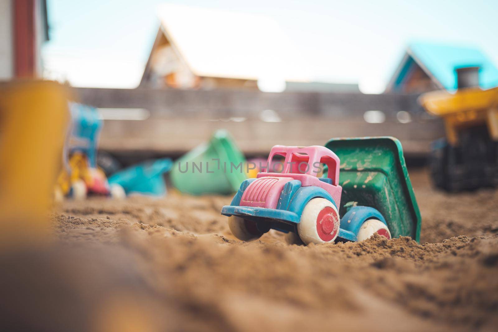 Children plastic toys in the sand box. Truck, selective focus.