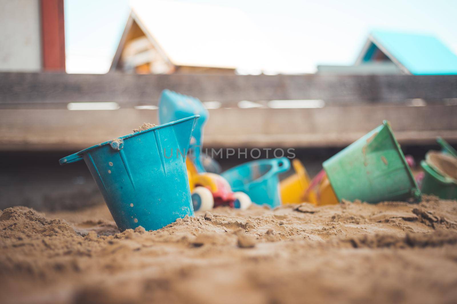 Children plastic toys in the sand box. Dirt bucket, selective focus.