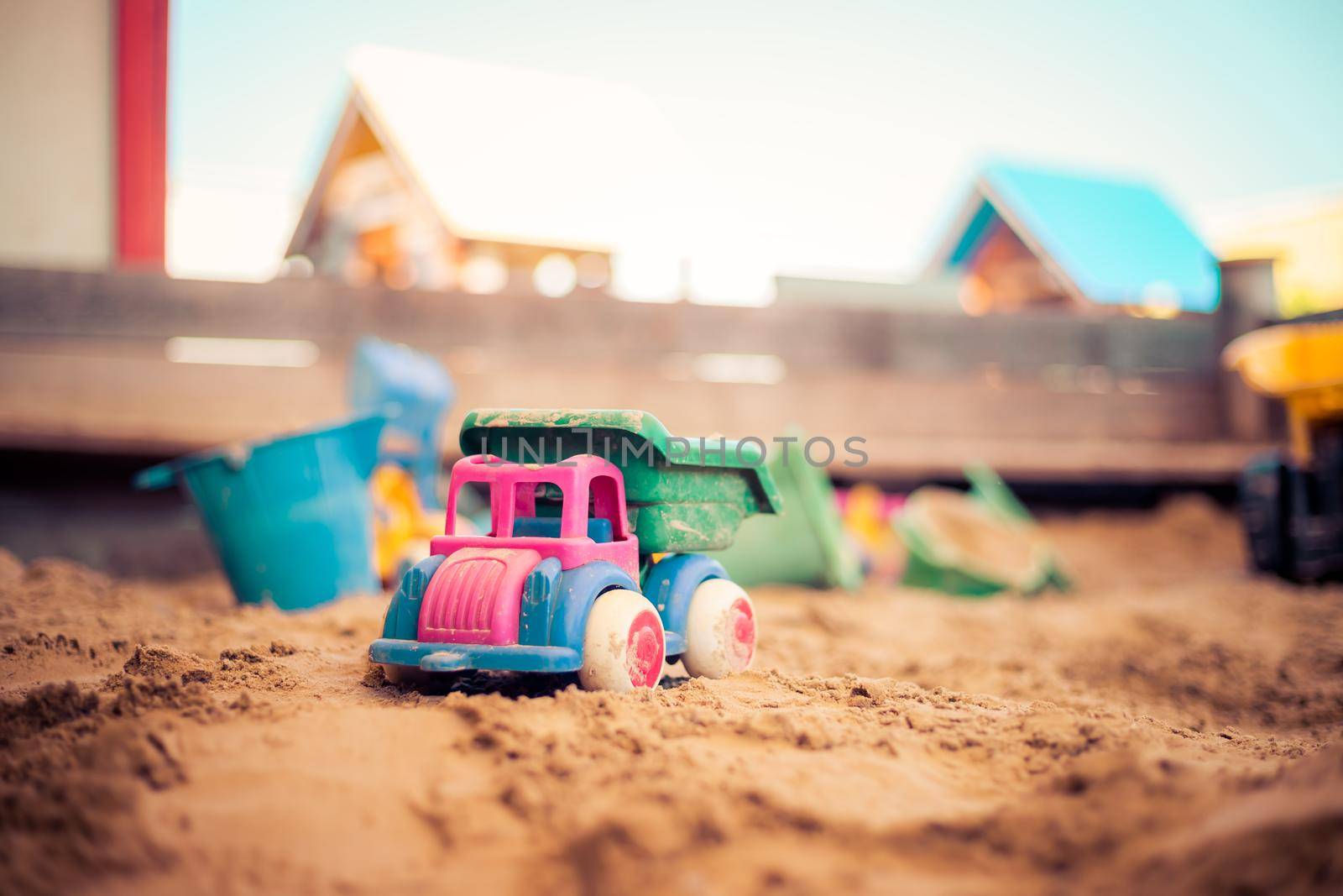 Children plastic toys in the sand box. Truck, selective focus.