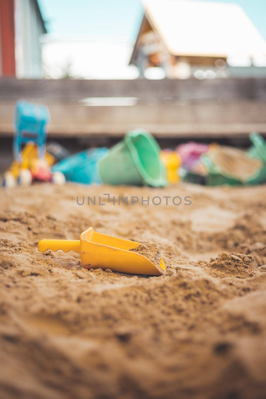 Children plastic toys in the sand box. Shovel, selective focus.