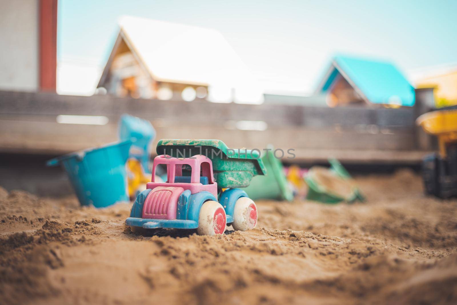 Children plastic toys in the sand box. Truck, selective focus.