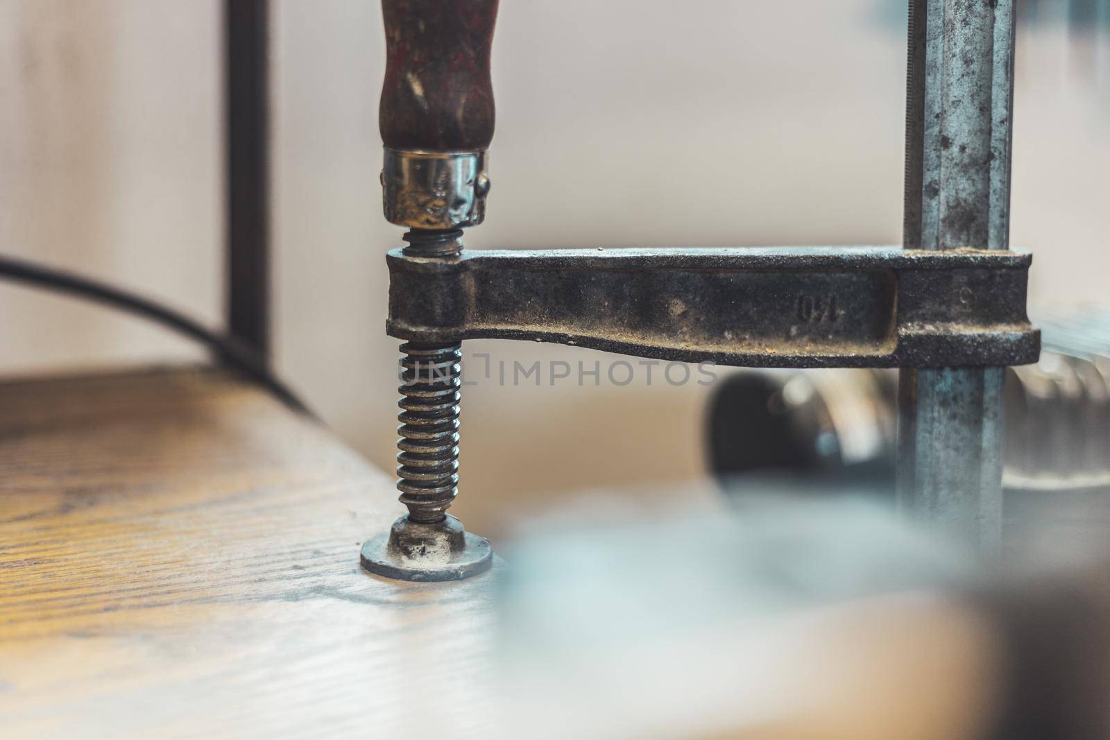Close up of a metal screw clamp in a garage workshop