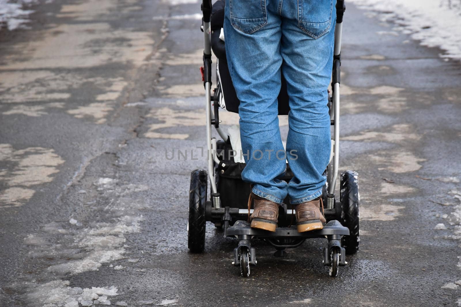 Back view of the man riding on troller board for kids and having fun - the concept of happy father by wektorygrafika