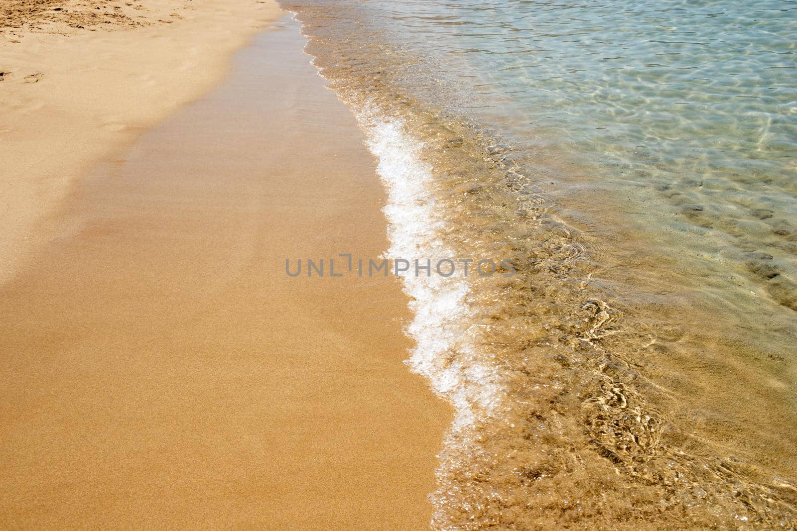 Mesmerizing shot of soft waves on a sandy beach by wektorygrafika