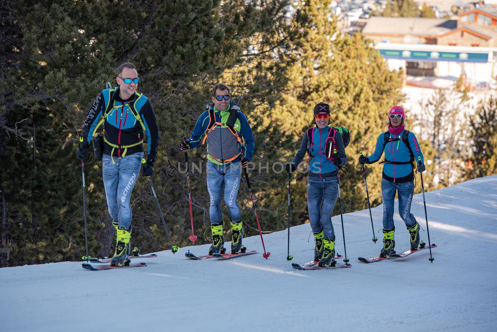 Grandvalira, Andorra: 2021 February 25: Skiers skiing in a forest on a sunny morning in the winter of 2021
