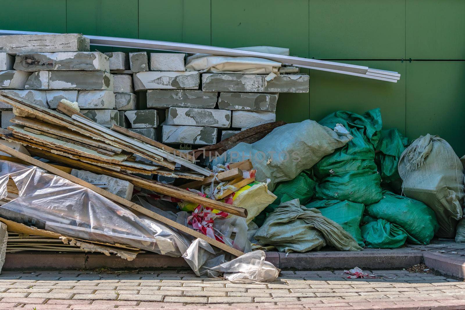 Construction waste dump in the shade behind a building under construction