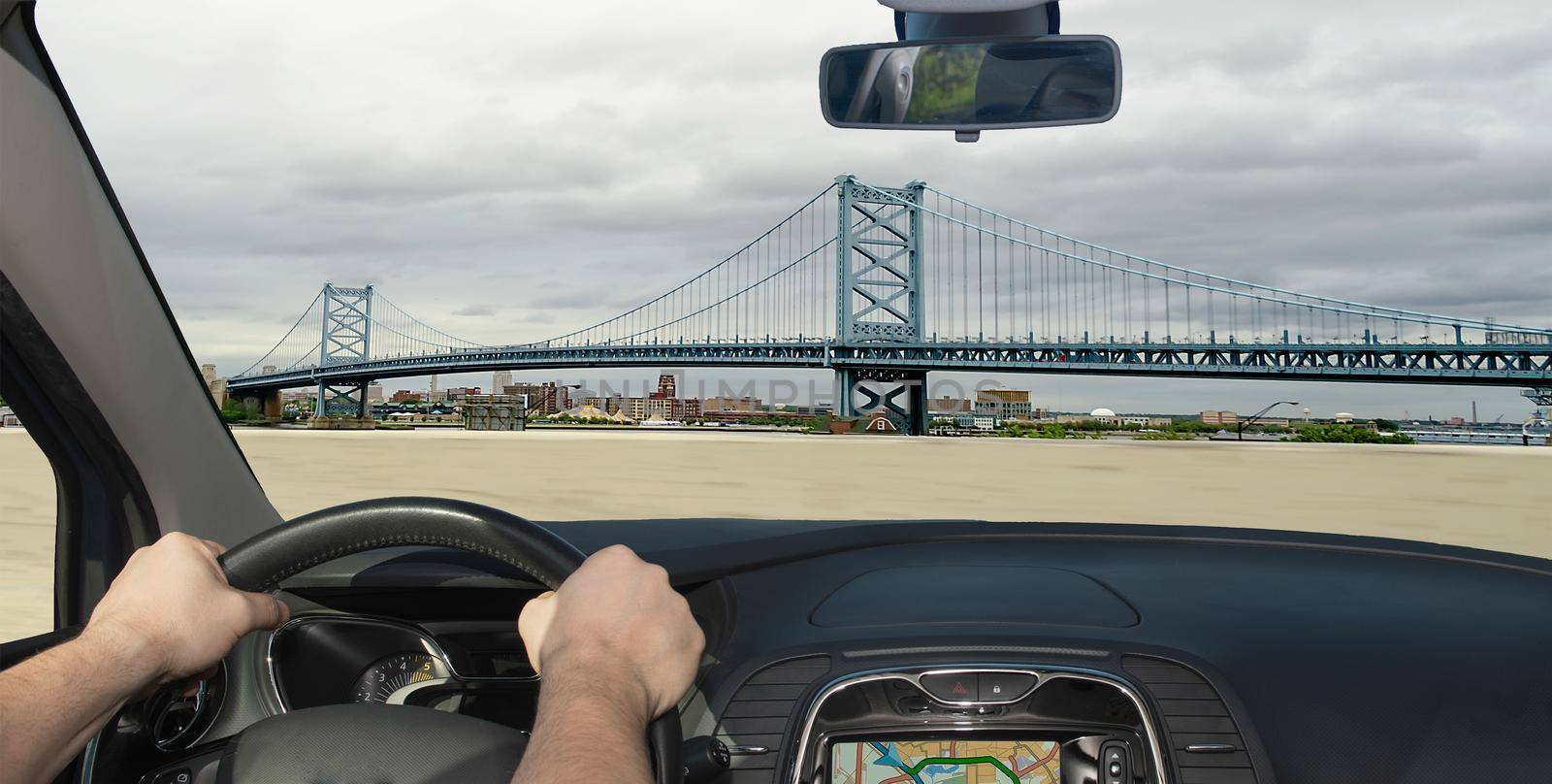 Driving a car towards Benjamin Franklin Bridge, iconic landmark in Philadelphia, Pennsylvania, USA