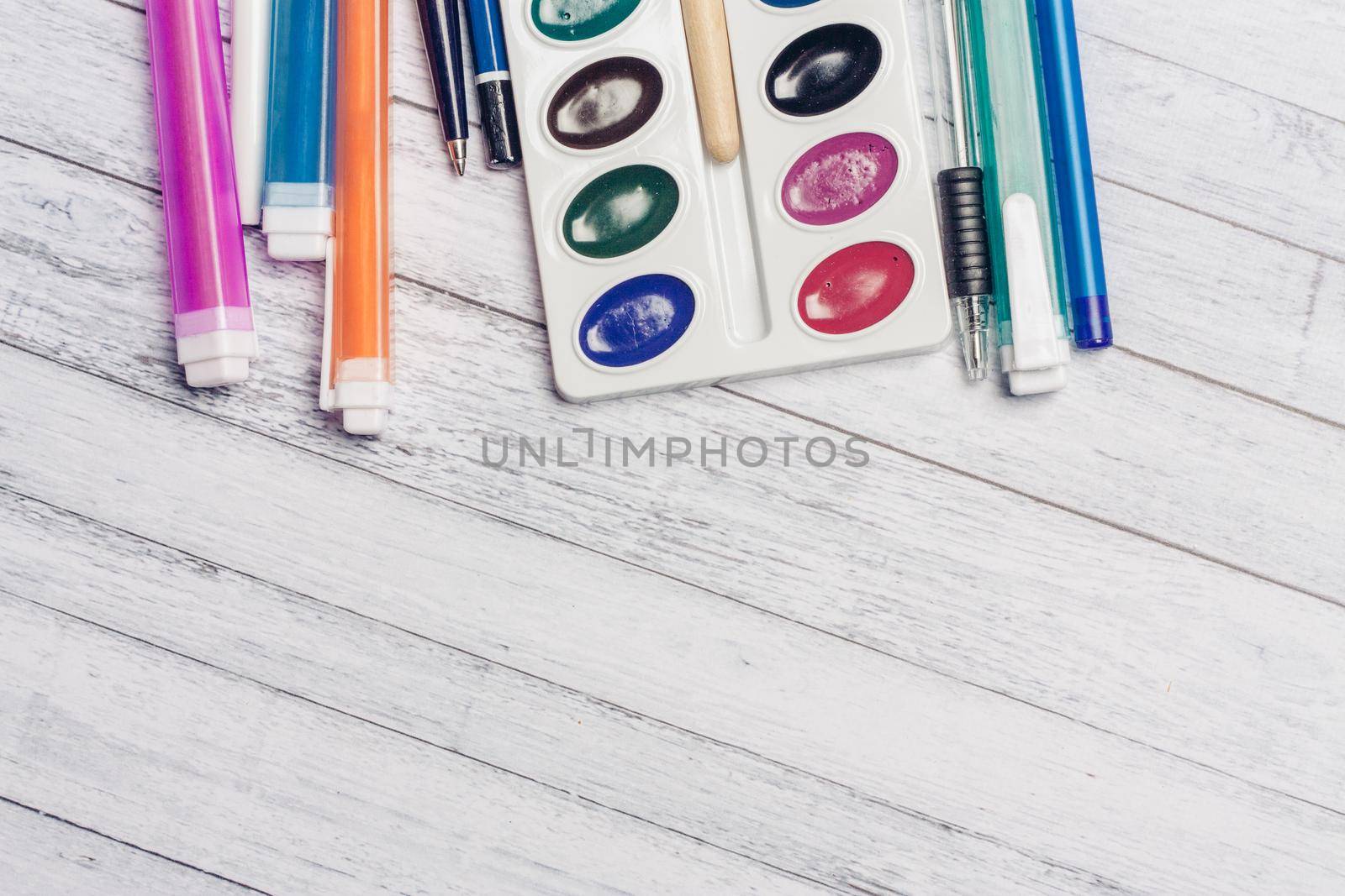 bright watercolor paints for painting and brush with a fine tip on a wooden background Copy Space. High quality photo