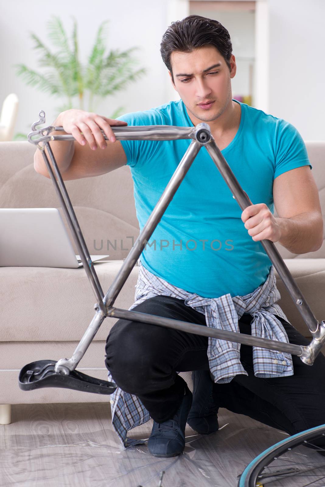 Young man repairing bicycle at home