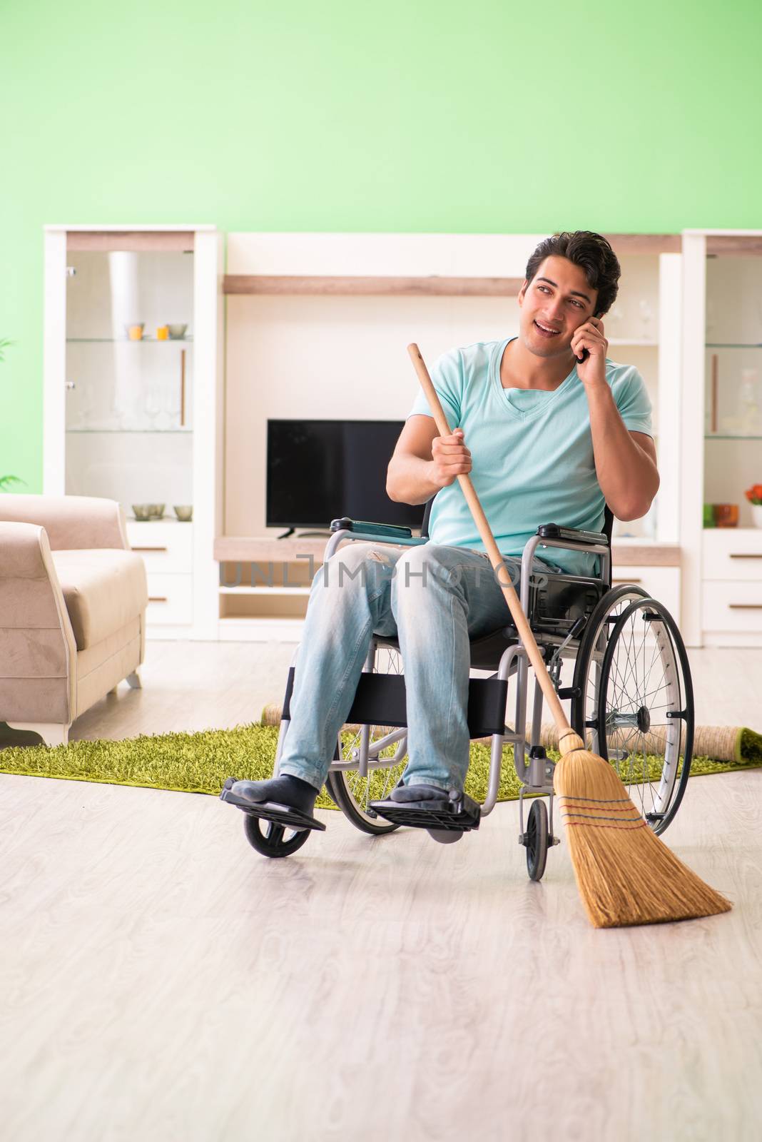Disabled man on wheelchair cleaning house