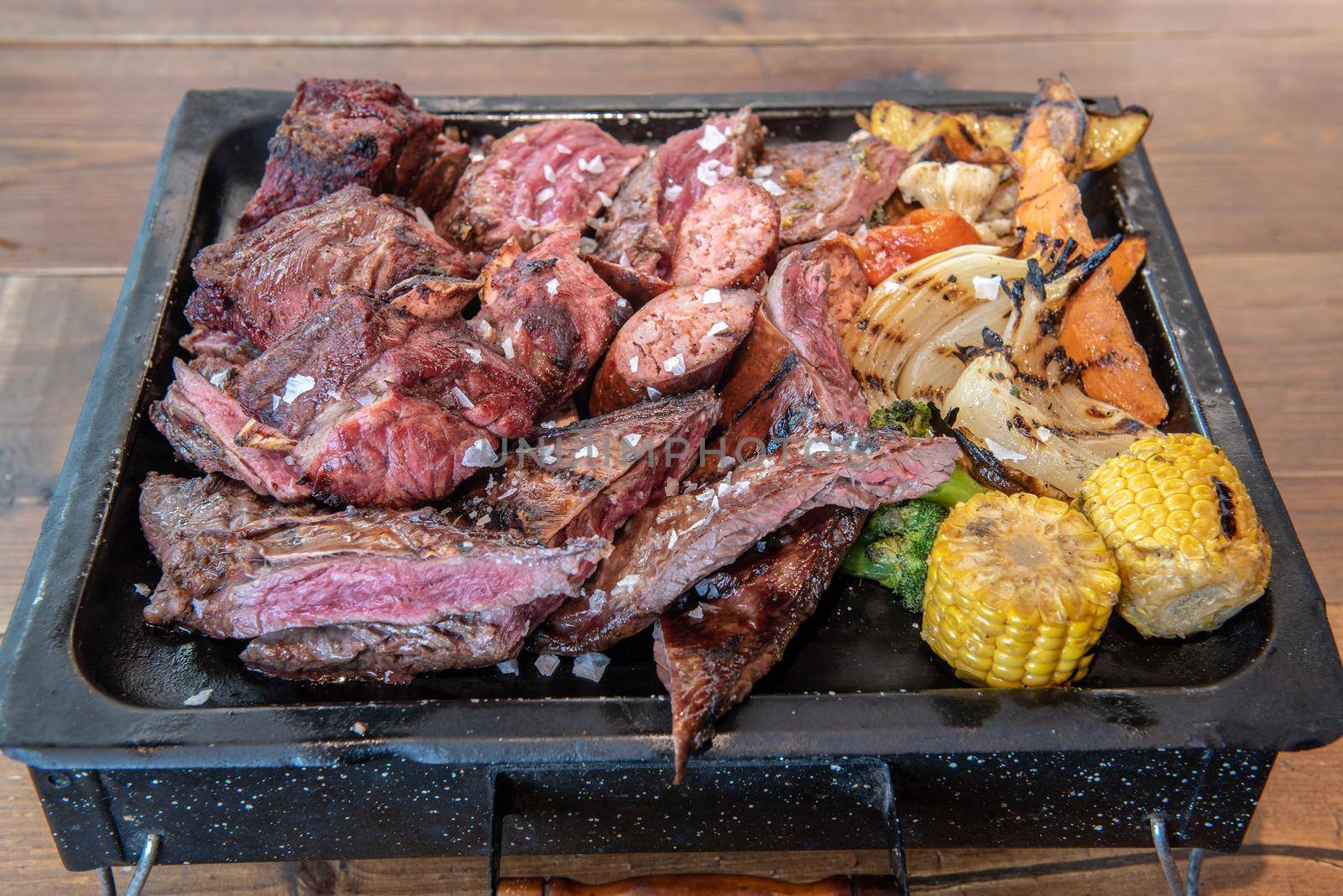 Complete grill of Argentine Asado of meat with vegetables and served in Brasero.