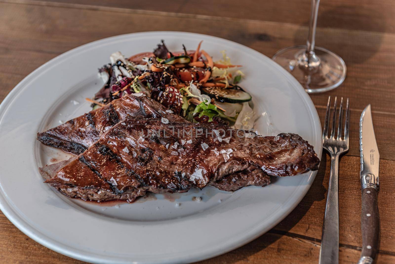 Argentine cut of meat called Entrana with vegetables and served on a white plate.