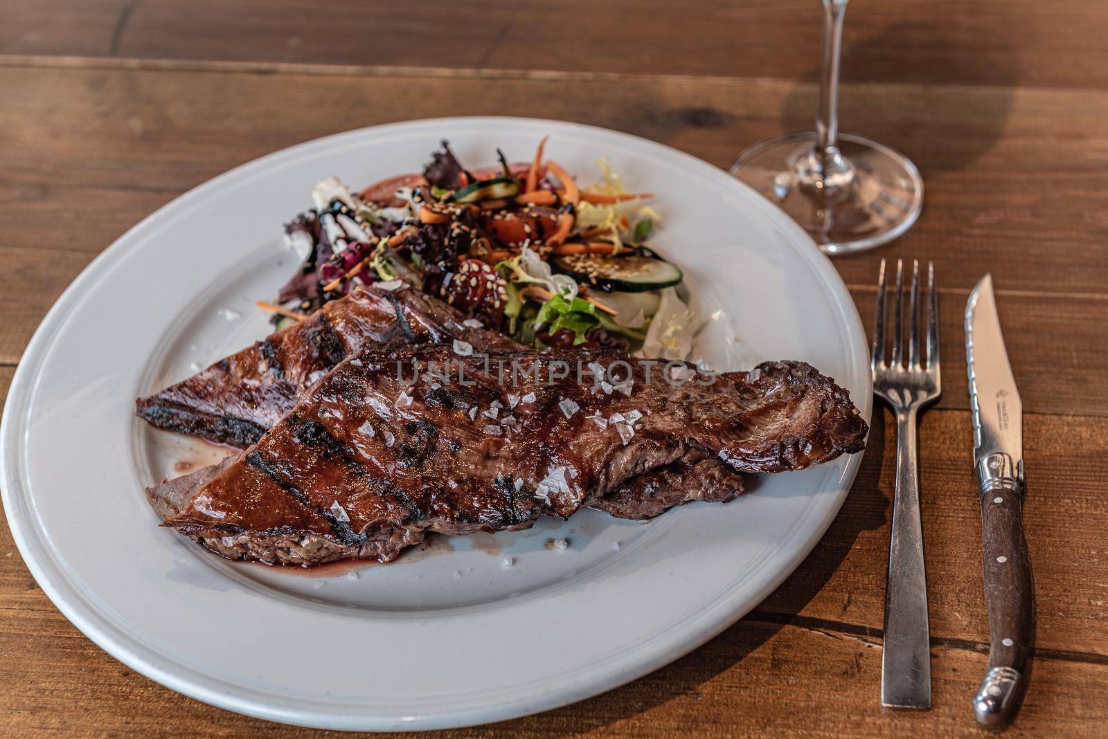 Argentine cut of meat called Entrana with vegetables and served on a white plate.