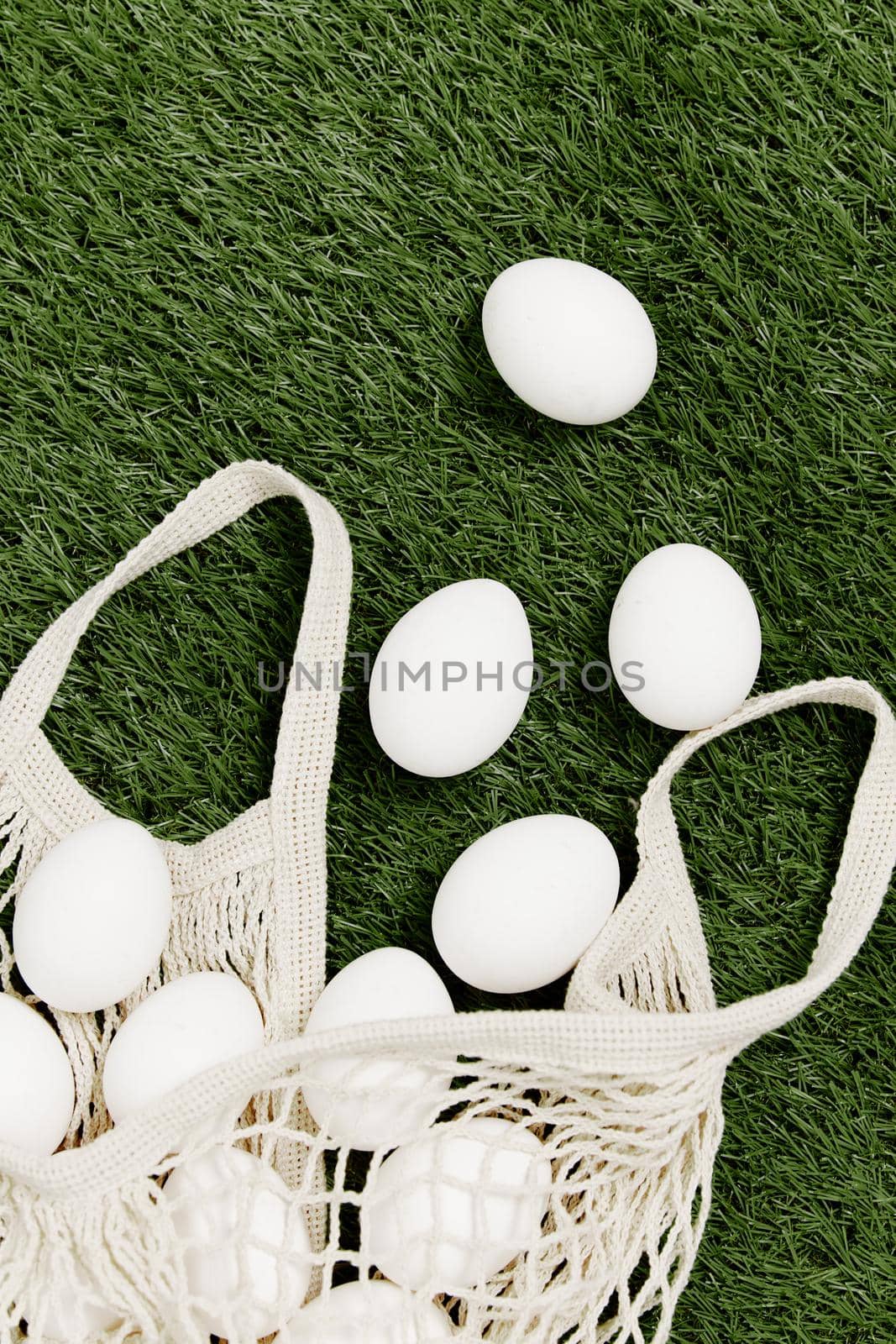 scattered bag with white eggs on the lawn holiday easter top view by SHOTPRIME