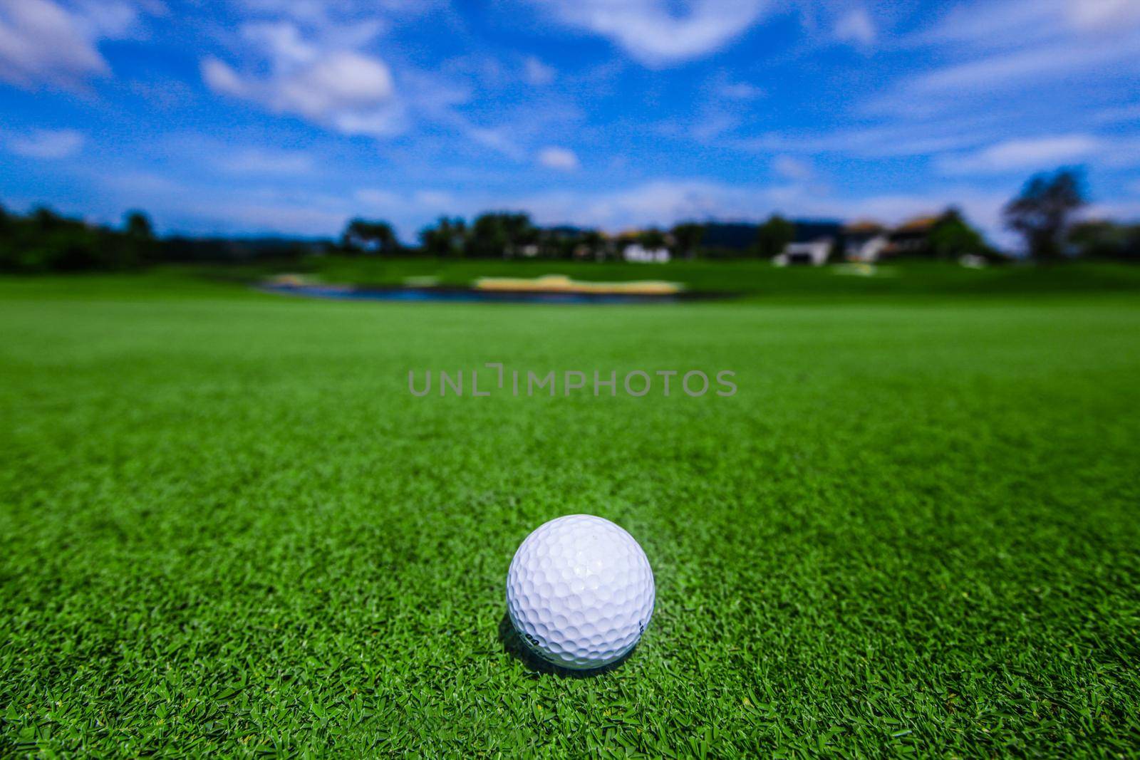 Golf ball on course, beautiful landscape with mountains on background