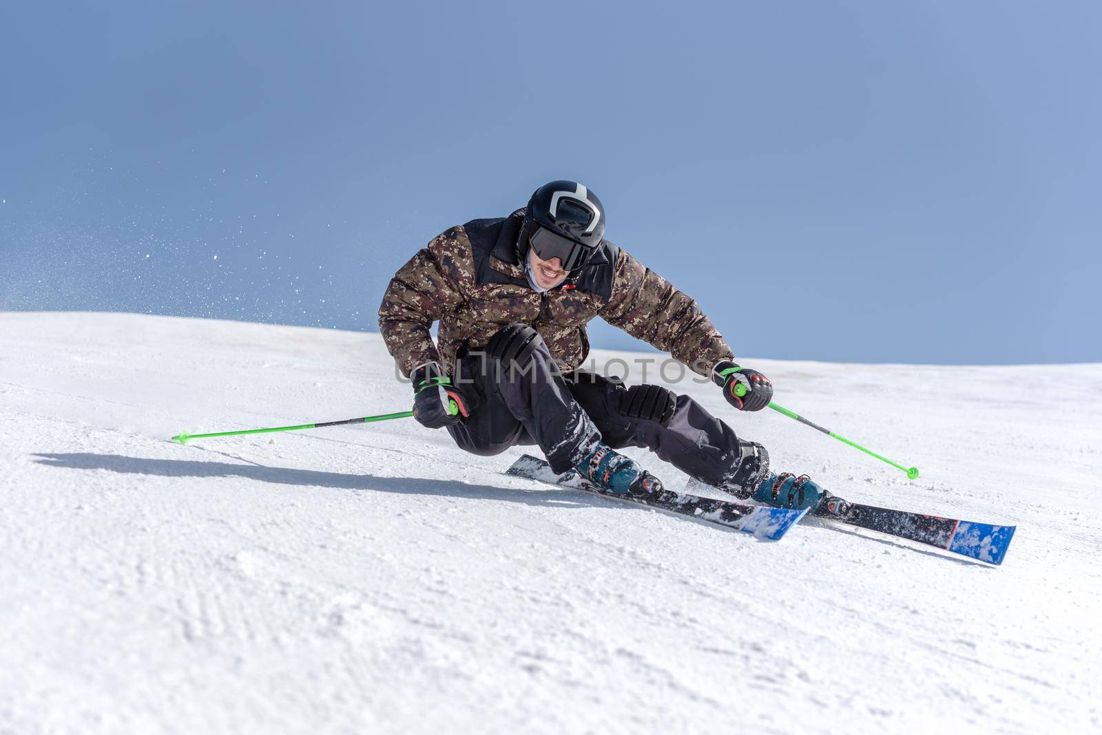 Young  man skiing on a sunny day in Andorra by martinscphoto