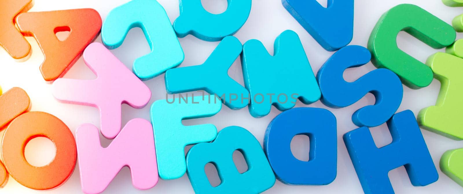 Colorful letter blocks scattered randomly on white by berkay