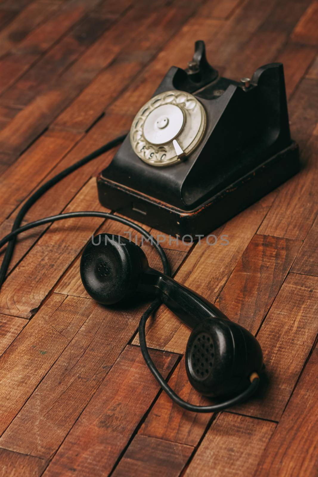 retro telephone black on a wooden floor classic to technology by SHOTPRIME