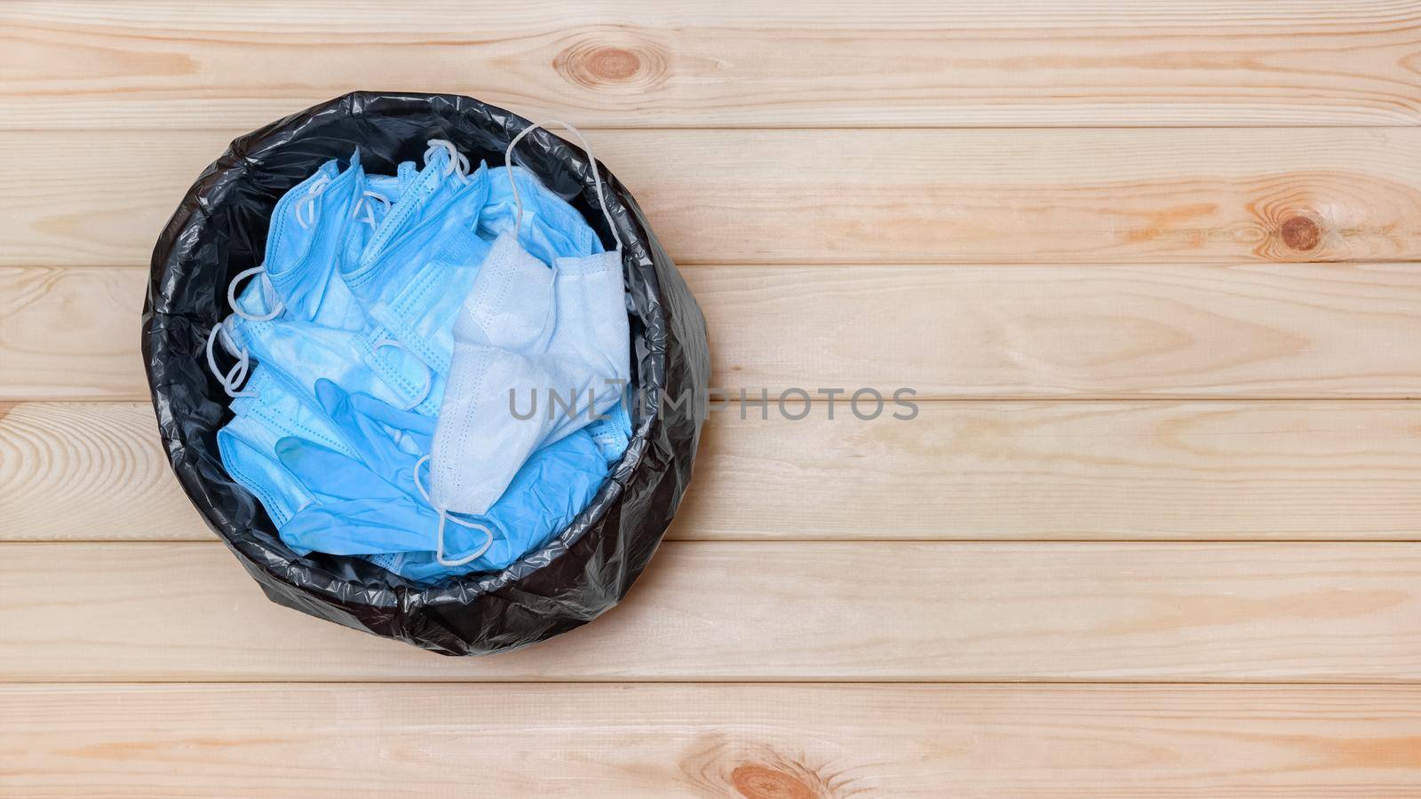 End covid waste banner masks in bin garbage after coronavirus is over. Disposable masks in office bin top view. Throw away mask in trash after pandemic end. Garbage basket with masks rubbish Covid 19