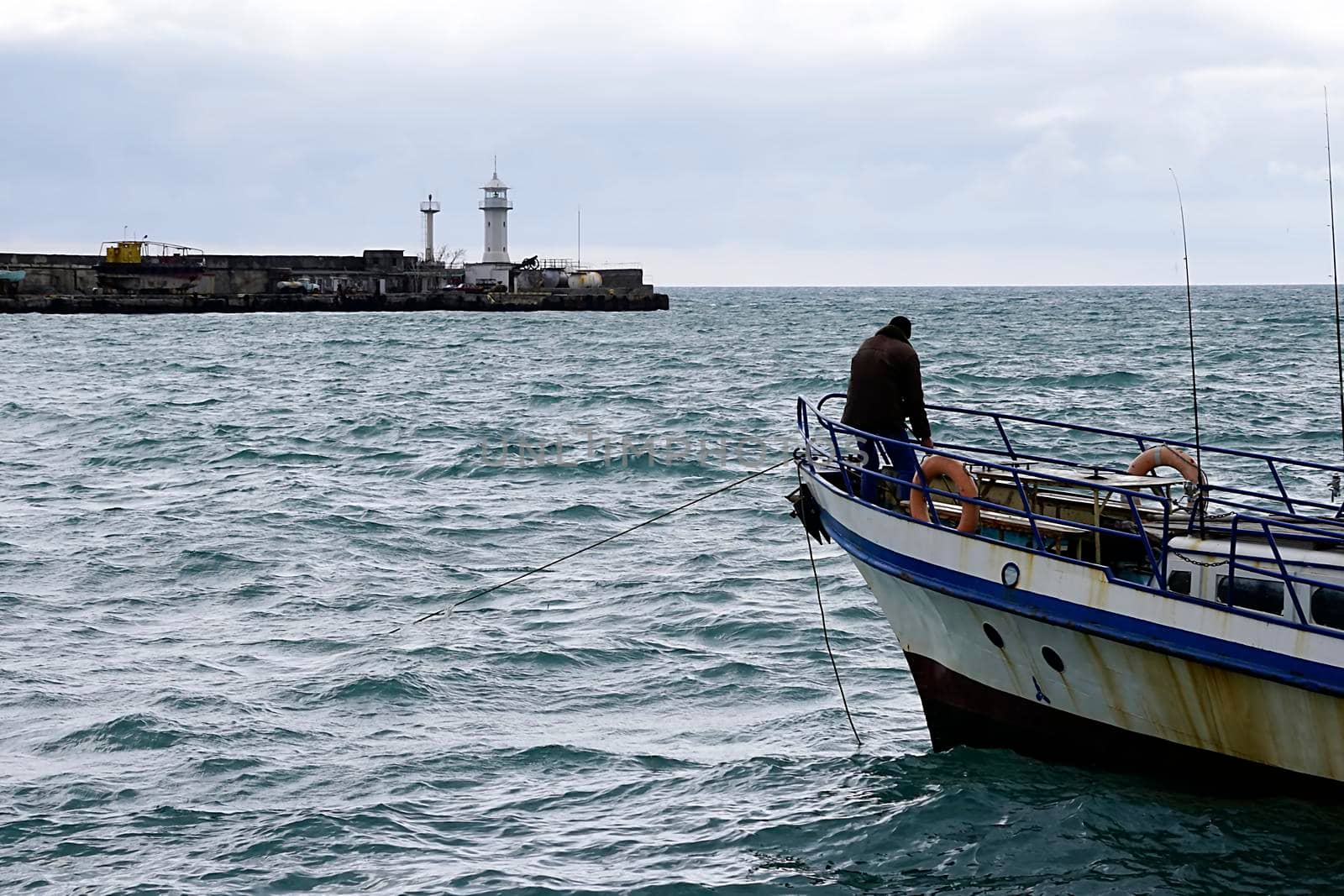 Seascape with a view of the fisherman on the bow of the ship. Yalta, Crimea