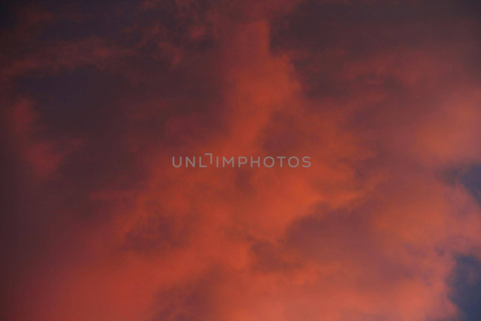 Dawn sunset sky with magestic orange clouds over blue background