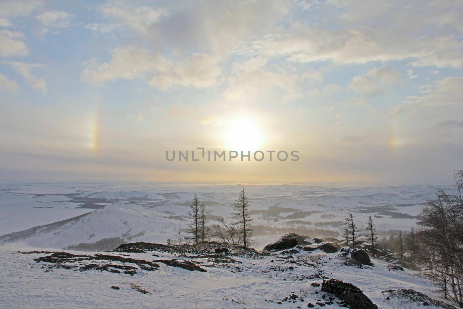 Halo effect over beautiful winter landscape with Lake Bannoe and mountains in snow in South Ural, Russia