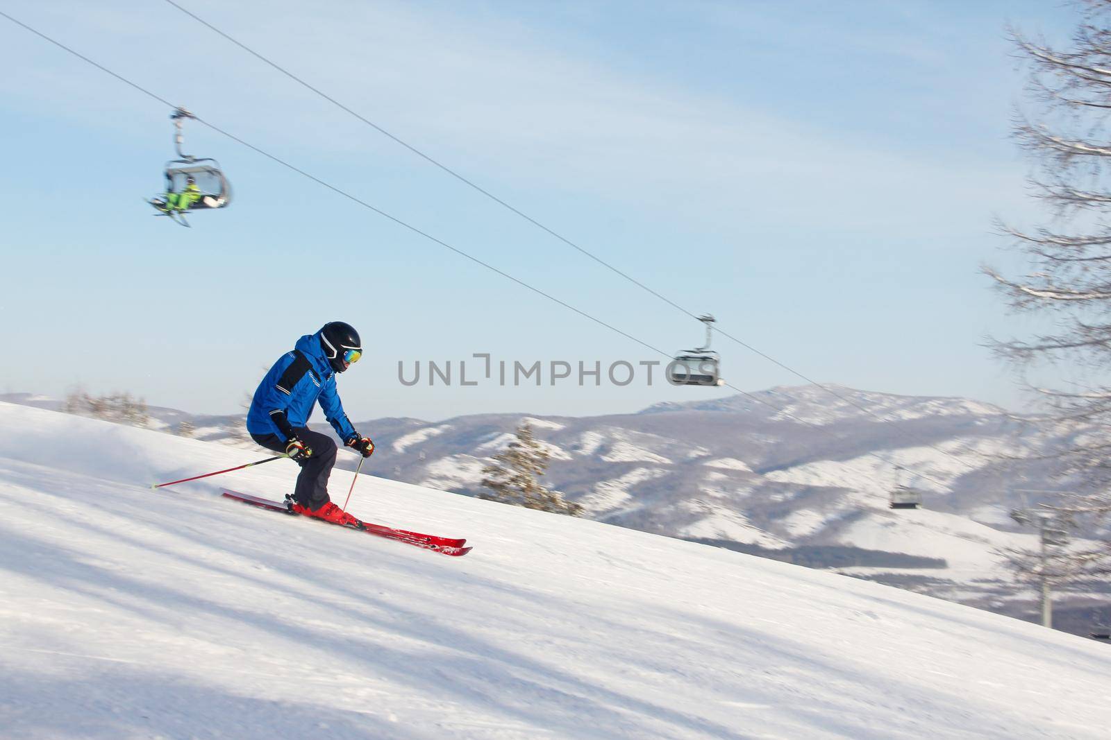 Male skier skiing downhill in mountains snowy day