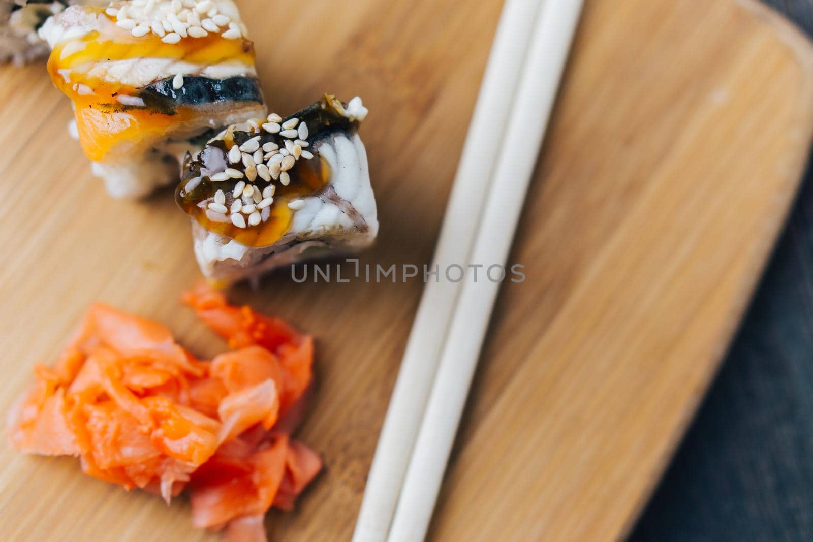 sushi rolls red ginger chopsticks wood board japanese cuisine. High quality photo