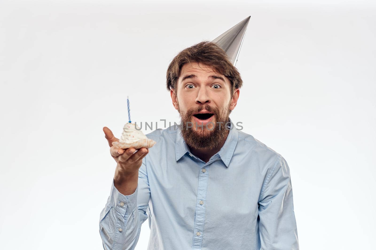 a man with a beard holds a cake in his hand on a light background birthday. High quality photo