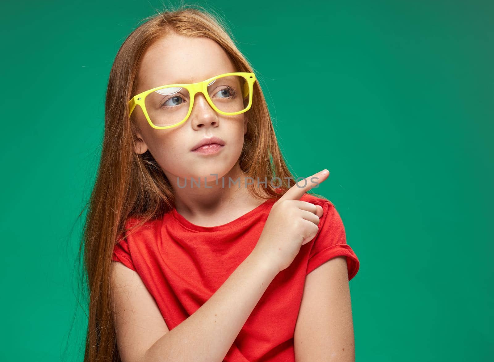 cute girl red hair glasses education school green background. High quality photo