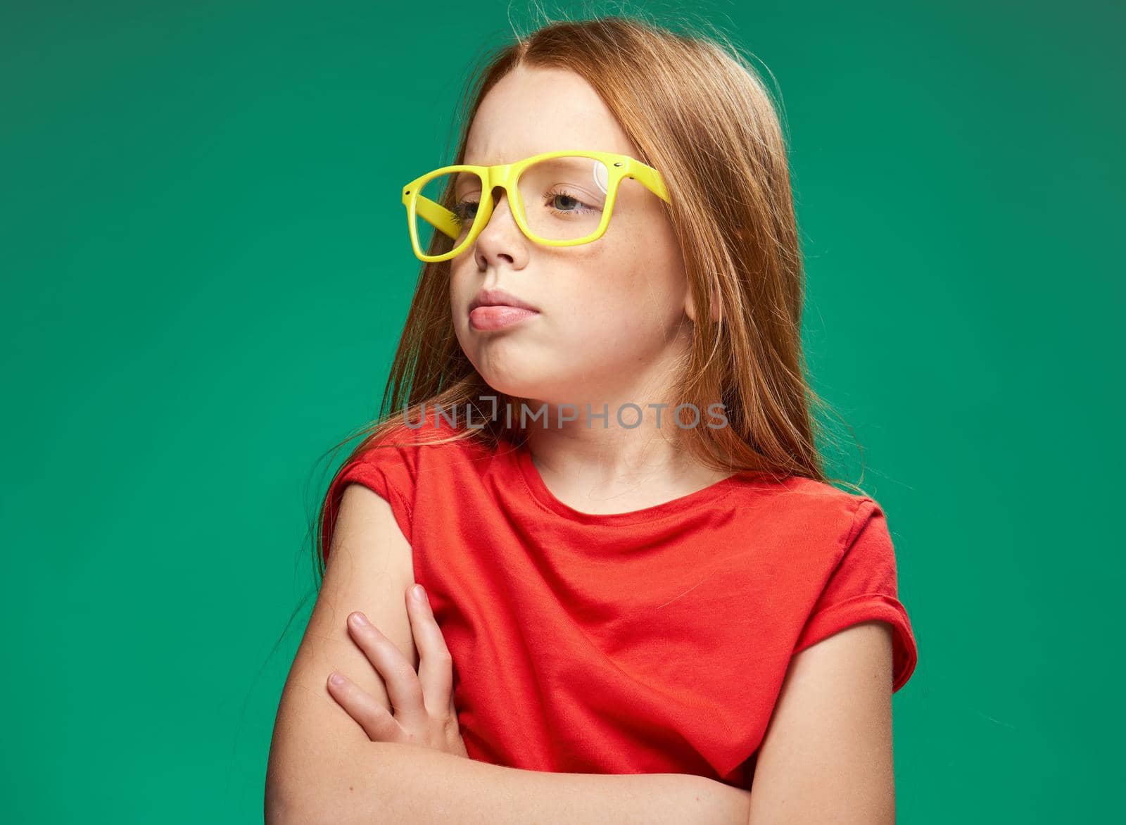 cute girl red hair glasses education school green background. High quality photo