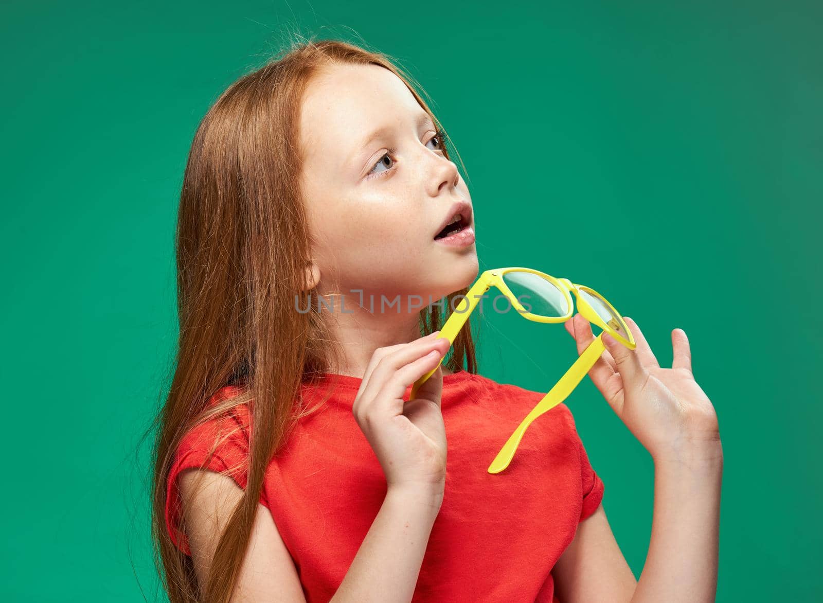 cute girl red hair glasses education school green background. High quality photo