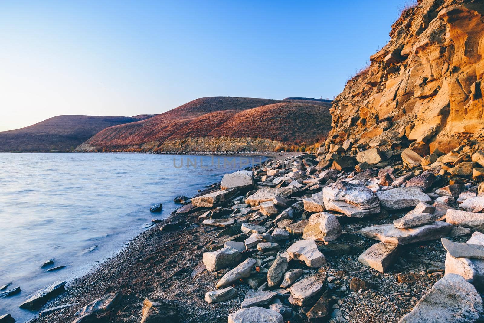 Hilly lake shore in sunrise light by Seva_blsv