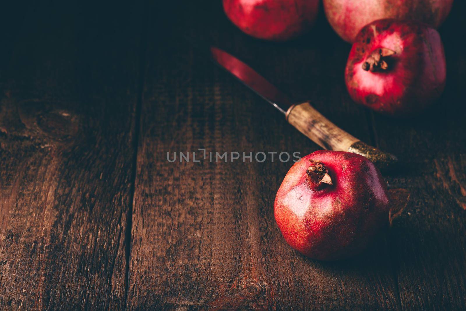 Red pomegranate fruits on rustic wooden surface