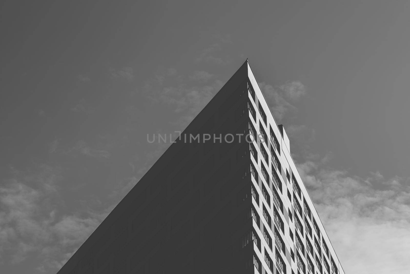 Angle of the Skyscraper on the Cloudy Sky Background. Black and White.