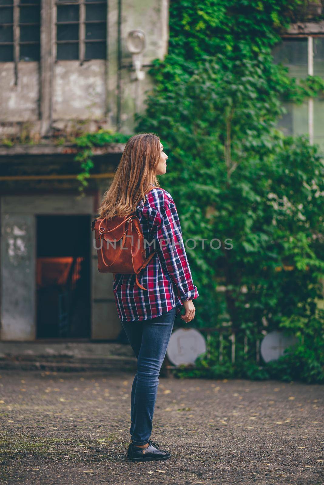 Young woman standing in a front of the old building by Seva_blsv