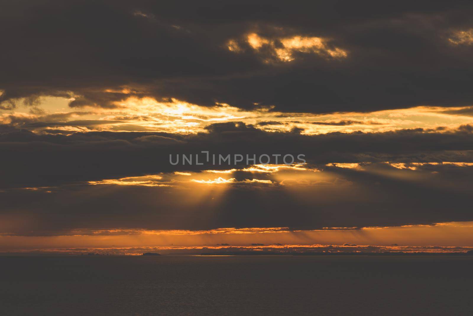 Sunrise on river. Sunbeams make a way through the clouds